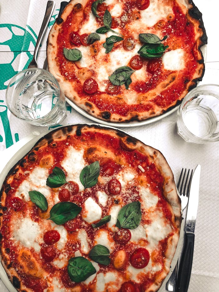 Two delicious pizzas topped with mozzarella and basil, perfect for a tasty meal.